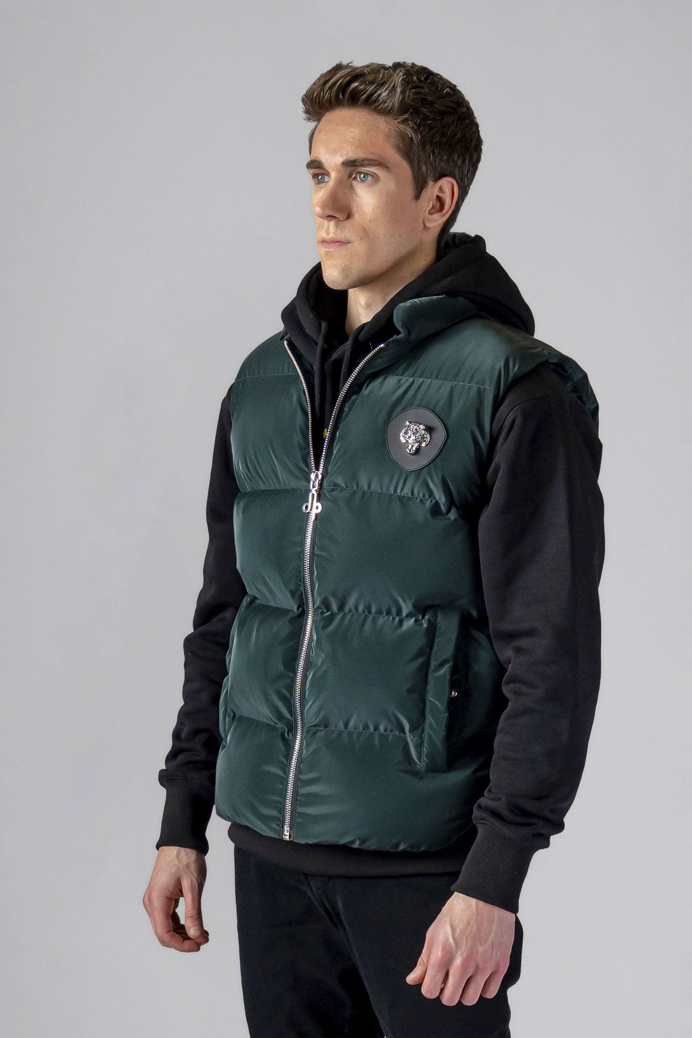 Woodpecker Unisex Winter Vest. High-end Canadian designer winter vest in "Green Diamond" colour. Woodpecker cruelty-free vest designed in Canada. Heavy weight short length premium designer vest for winter. Superior quality warm winter vest. Moose Knuckles, Canada Goose, Mackage, Montcler, Will Poho, Willbird, Nic Bayley. Extra warm. Shiny vest. Stylish winter vest. Designer winter vest.