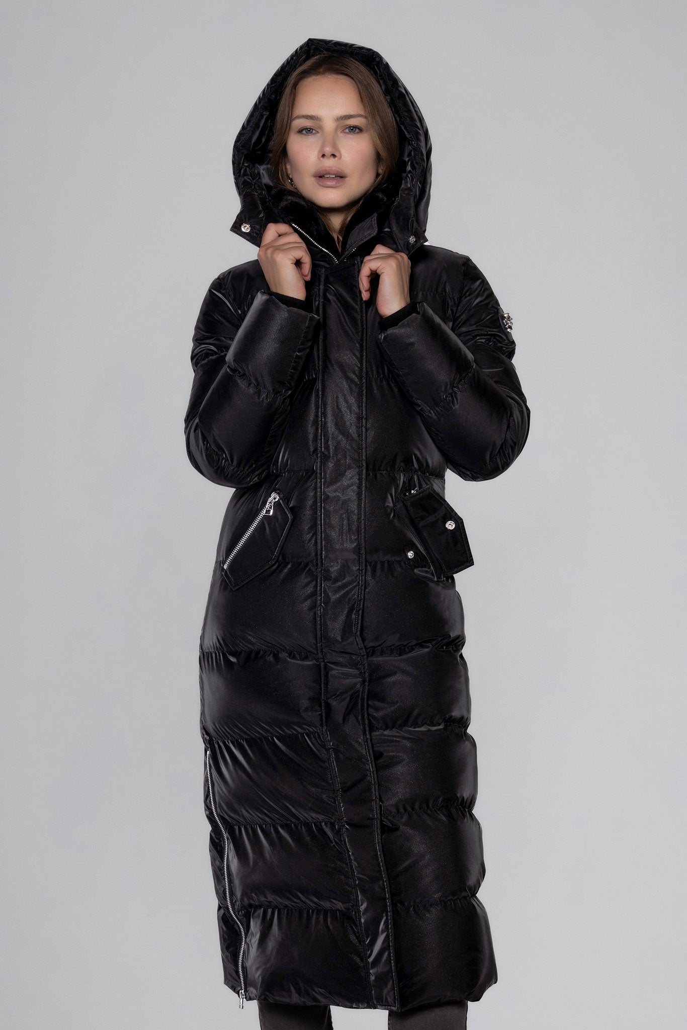 Woodpecker Women's Extra Long Bird of Paradise Winter coat. High-end Canadian designer winter coat for women in “Black Diamond" colour. Woodpecker cruelty-free winter coat designed in Canada. Women's heavy weight extra long length premium designer jacket for winter. Superior quality warm winter coat for women. Moose Knuckles, Canada Goose, Mackage, Montcler, Will Poho, Willbird, Nic Bayley. Extra warm. Shiny parka. Stylish winter jacket. Designer winter coat.