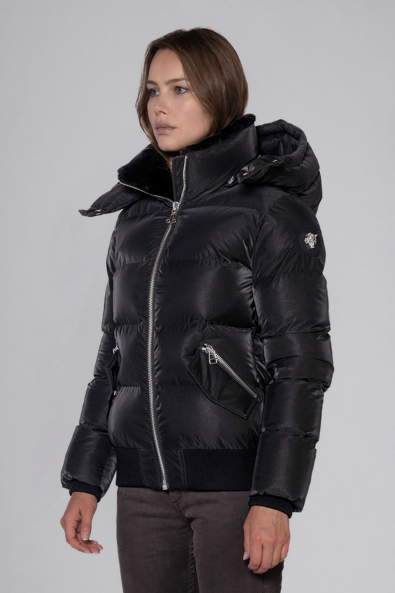 Woodpecker Women's Woody Bomber Winter coat. High-end Canadian designer winter coat for women in "Black Diamond" colour. Woodpecker cruelty-free winter coat designed in Canada. Women's heavy weight short length premium designer jacket for winter. Superior quality warm winter coat for women. Moose Knuckles, Canada Goose, Mackage, Montcler, Will Poho, Willbird, Nic Bayley. Shiny parka. Stylish winter jacket. Designer winter coat.