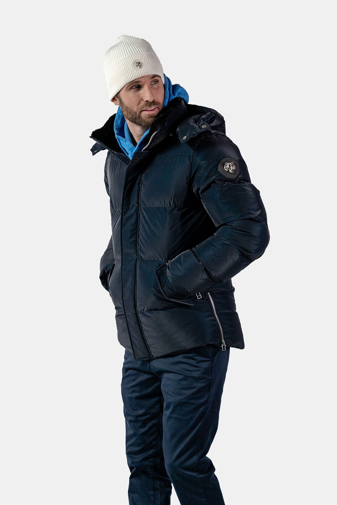 Woodpecker Men's Bumnester Bomber Winter coat. High-end Canadian designer winter coat for men in "Blue Diamond" colour. Woodpecker cruelty-free winter coat designed in Canada. Men's heavy weight medium length premium designer jacket for winter. Superior quality warm winter coat for men. Moose Knuckles, Canada Goose, Mackage, Montcler, Will Poho, Willbird, Nic Bayley. Shiny parka. Stylish winter jacket. Designer winter coat.