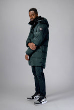Load image into Gallery viewer, Woodpecker Men&#39;s Penguin Long Winter coat. High-end Canadian designer winter coat for men in &quot;Green Diamond&quot; colour. Woodpecker cruelty-free winter coat designed in Canada. Men&#39;s heavy weight long length premium designer jacket for winter. Superior quality warm winter coat for men. Moose Knuckles, Canada Goose, Mackage, Montcler, Will Poho, Willbird, Nic Bayley. Extra warm. Shiny parka. Stylish winter jacket. Designer winter coat.
