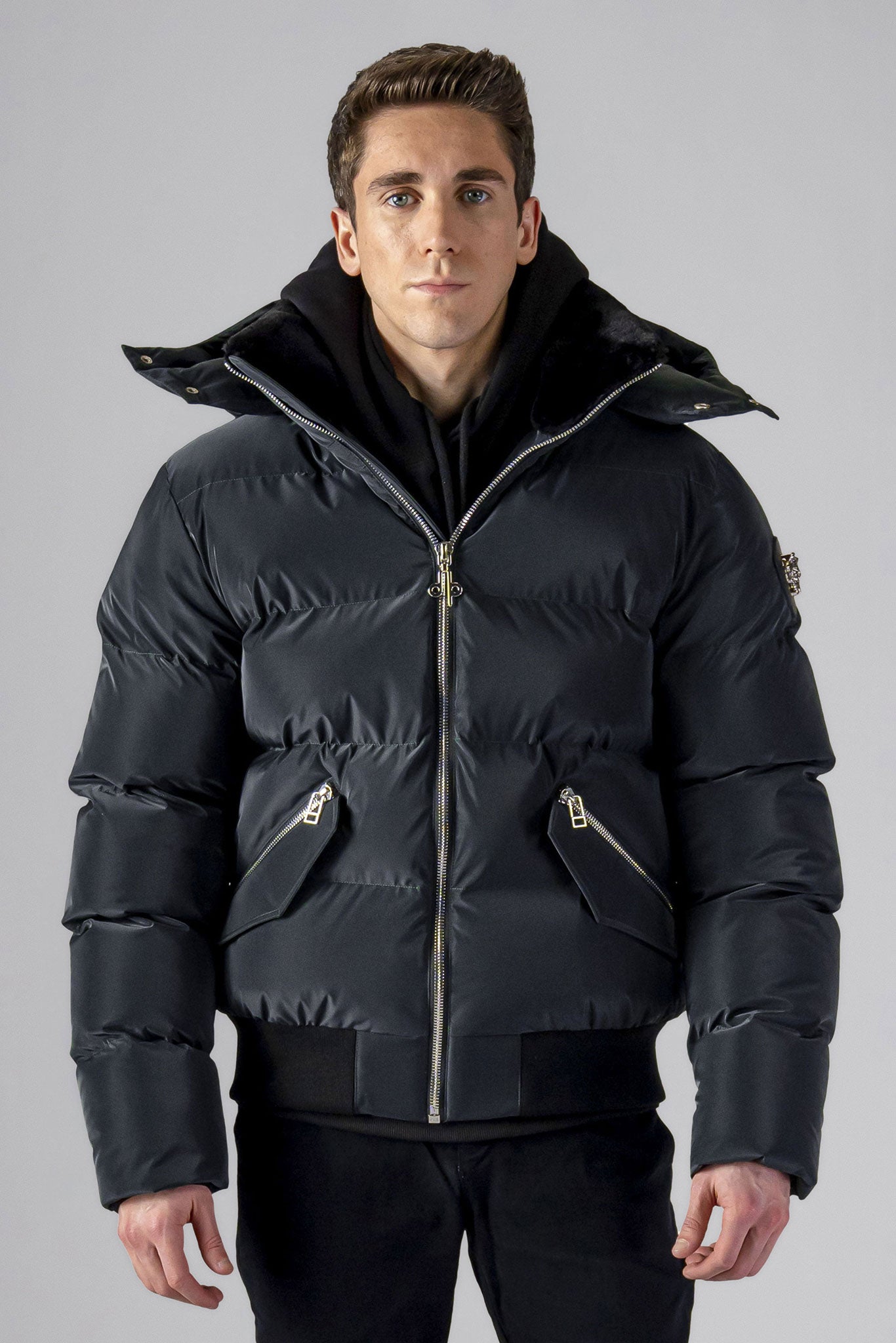 Woodpecker Men's Woody Bomber Winter coat. High-end Canadian designer winter coat for men in "Black Diamond" colour. Woodpecker cruelty-free winter coat designed in Canada. Men's heavy weight short length premium designer jacket for winter. Superior quality warm winter coat for men. Moose Knuckles, Canada Goose, Mackage, Montcler, Will Poho, Willbird, Nic Bayley. Shiny parka. Stylish winter jacket. Designer winter coat.