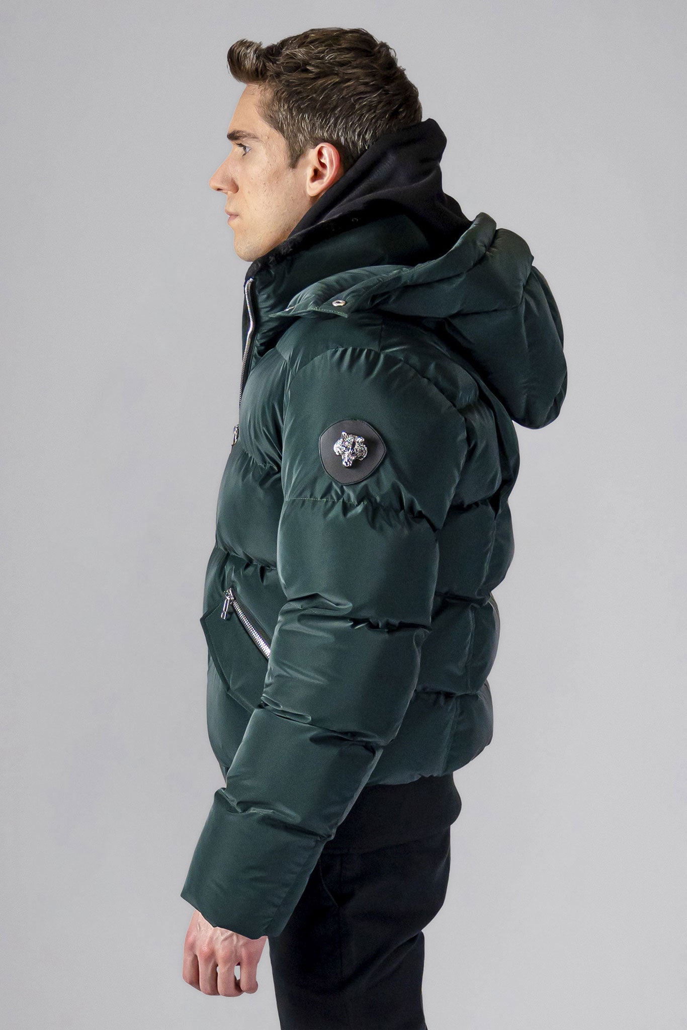 Woodpecker Men's Woody Bomber Winter coat. High-end Canadian designer winter coat for men in "Green Diamond" colour. Woodpecker cruelty-free winter coat designed in Canada. Men's heavy weight short length premium designer jacket for winter. Superior quality warm winter coat for men. Moose Knuckles, Canada Goose, Mackage, Montcler, Will Poho, Willbird, Nic Bayley. Shiny parka. Stylish winter jacket. Designer winter coat.