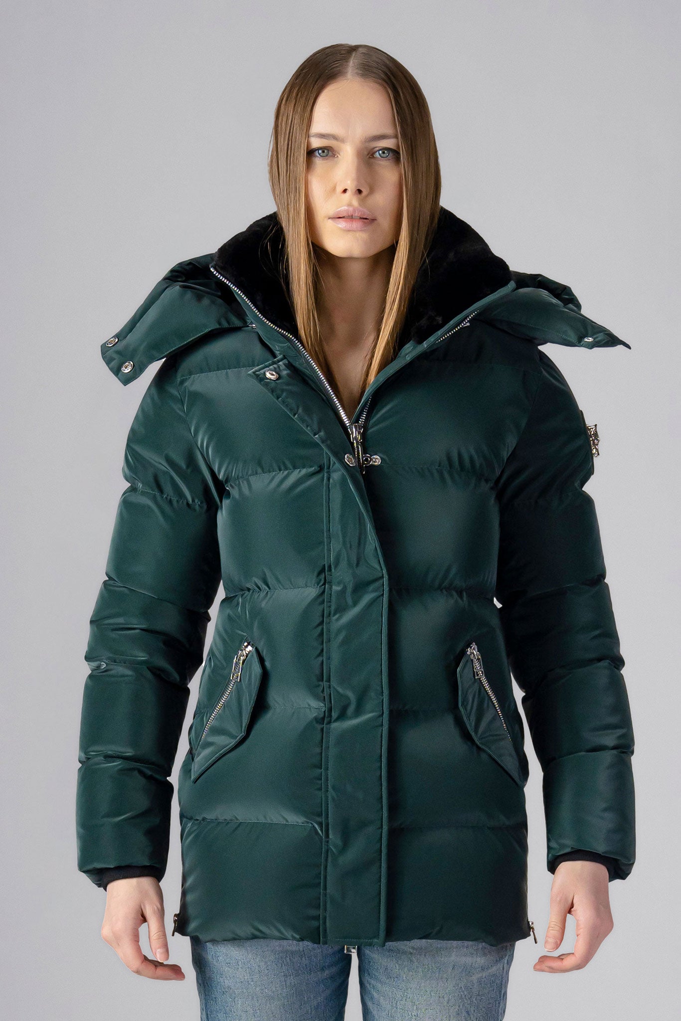 Woodpecker Women's Bumnester Winter coat. High-end Canadian designer winter coat for women in shiny "Green Diamond" colour. Woodpecker cruelty-free winter coat designed in Canada. Women's heavy weight medium length premium designer jacket for winter. Superior quality warm winter coat for women. Moose Knuckles, Canada Goose, Mackage, Montcler, Will Poho, Willbird, Nic Bayley. Extra warm. Shiny parka. Stylish winter jacket. Designer winter coat.