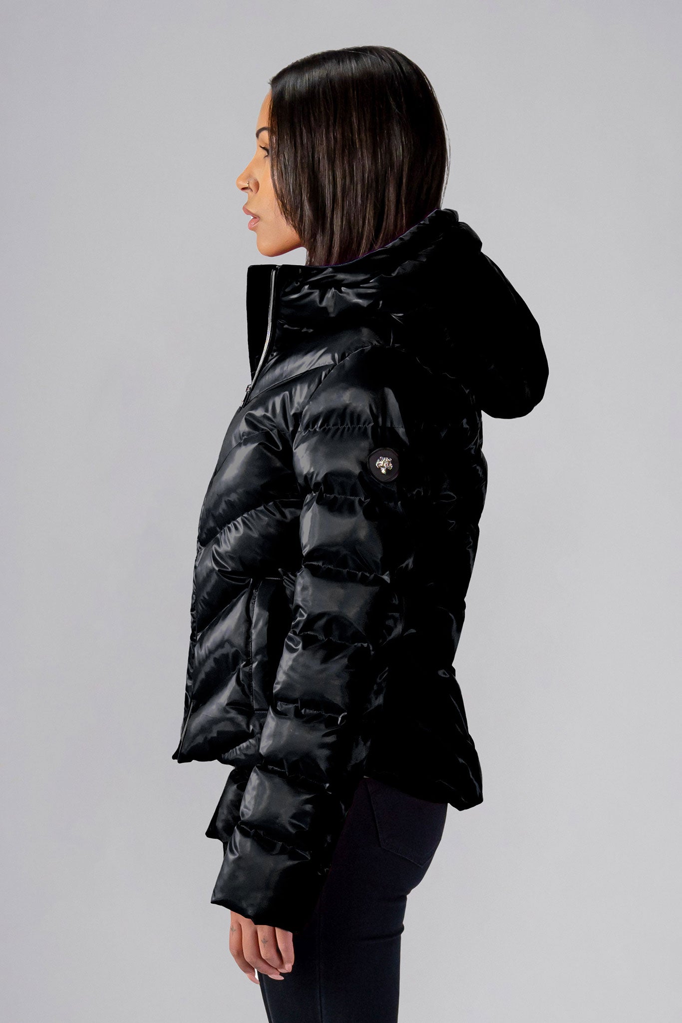 Woodpecker Women's Robin Winter coat. High-end Canadian designer winter coat for women in "All Wet Black" colour. Woodpecker cruelty-free winter coat designed in Canada. Women's medium weight medium length premium designer jacket for winter. Superior quality warm winter coat for women. Moose Knuckles, Canada Goose, Mackage, Montcler, Will Poho, Willbird, Nic Bayley. Extra warm. Shiny parka. Stylish winter jacket. Designer winter coat.